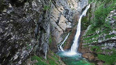 Amazing View of Waterfall Savica in Alps Mountains, deep clean blue water and green forest. Triglav National Park.