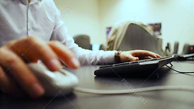 Keyboard 44. Soft focus to hand of the man clicking mouse button and typing document and numpad on keyboard. Right hand