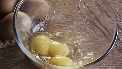 Hand cracking egg into a bowl