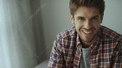 Happy young man. Portrait of handsome young man in casual shirt keeping arms crossed and smiling
