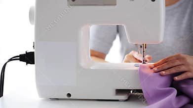 Tailor woman with sewing machine stitching fabric