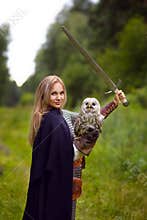 Girl in armor with owl holds a raised sword