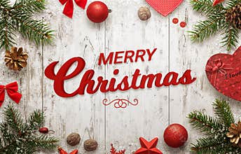 Merry Christmas text on white wooden surface. Christmas tree