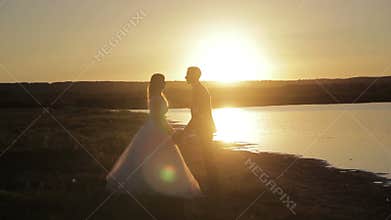 Bride and groom walking at sunset