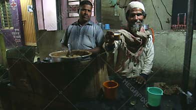 Indian men selling chai at a street stand in the night time in Mumbai.