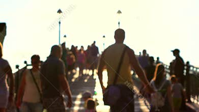 Blurred people walk on sunny park arched bridge. 4K bokeh shot