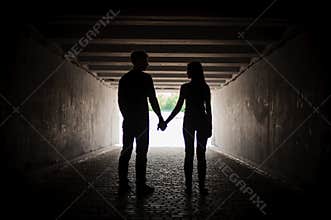 Silhouette of young couple holding hands