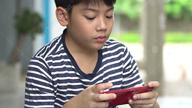 Asian boy using smart cell phone near the road