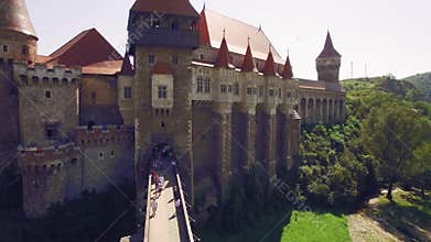 Close aerial view of a medieval castle with bridge surrounded by green park