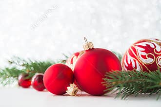 Red ornaments and xmas tree on glitter holiday background. Merry christmas card.