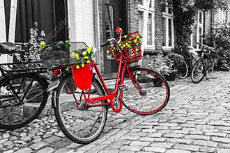 Retro vintage red bicycle on cobblestone street in the old town.