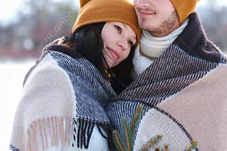 Portrait of young couple smiling and hugging in winter on backgr