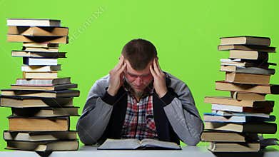 Man leafing through a textbook, it suffers from headaches. Green screen