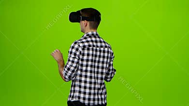 Man in vr glasses on head. Back view. Green screen