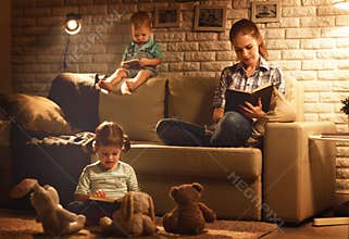 Family before going to bed mother and children read books and pl