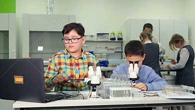 School science concept. Elementary school students doing a science experiment with snails.