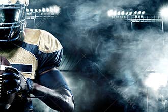 American football sportsman player on stadium with lights on background with copy space