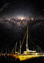 Night sky showing stars and milky way with boats in the foreground