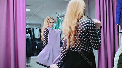 Young, beautiful woman checking her appearance in front of the mirror