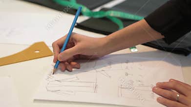 Tailor.Hands notch tailor tailor`s scissors cloth. Female tailor stitching material at workplace. Preparing fabric for