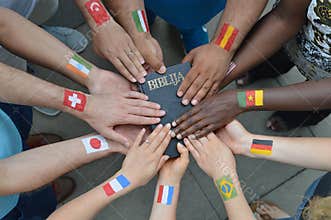 International people with flags holding a bible