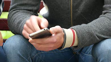 Man with a smartphone in his hands shows something to another person and gesturing.