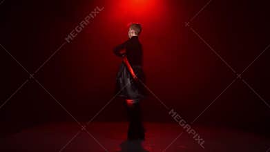 Red background. Man is dancing solo with red black cloth