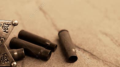 Sheriff badge and bullet cases on stone.