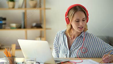Smiling student in headphones taking part in online courses