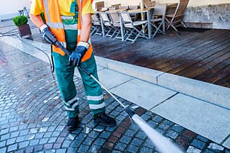 Worker cleaning the cobbled street