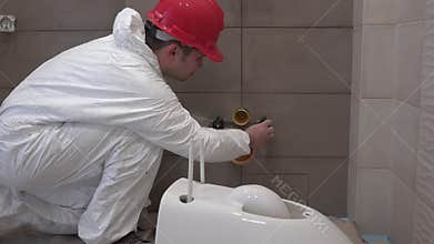 Professional plumber man preparing for toilet pan bowl mount in new bathroom