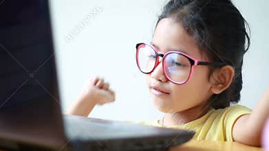 Asian little girl using laptop computer with happiness and cheerful