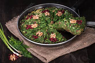 Persian Mixed herbs frittata with barberry and walnut in pan Kuku and Zereshk