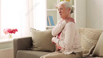 Senior woman suffering from neck pain at home