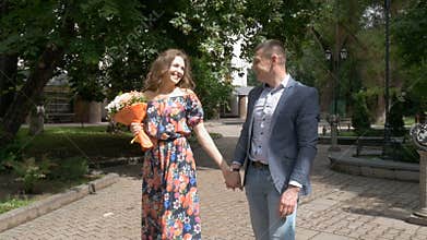 A beautiful romantic couple is walking in the park. Date. Slow motion