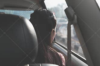 Behind of girl travel along the way and looking through window inside car