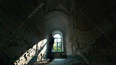 Young man in despair goes to an abandoned house. Concept: job loss, depression, unemployment, despair, grief