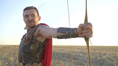 Evil archer in armor fires from an bow, slow motion