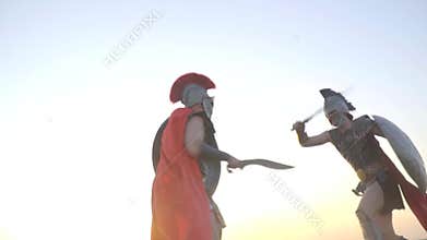 Bottom view as two strong warriors fight on the blue sky, slow motion