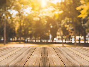 Wooden board empty table in front of blurred background. Perspective brown wood table over blur trees in forest background