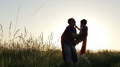 Father and son playing superhero at the sunset time.