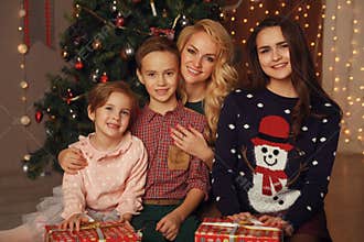 Happy parents and children sharing Christmas hugs.