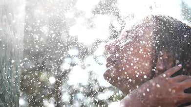 Woman taking a shower in slow motion in nature. Slow motion.