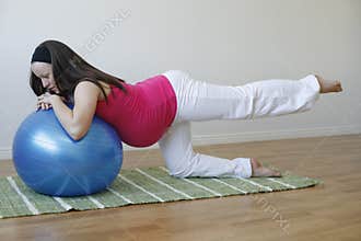 Young pregnant woman doing leg muscle exercise