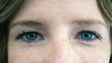 Close up of blue eyes young woman face