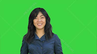Positive asian businesswoman talking, looking at camera on a Green Screen, Chroma Key