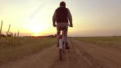 Boy teenager riding a bicycle. Boy teenager riding a bicycle goes to nature along the path steadicam video shot motion