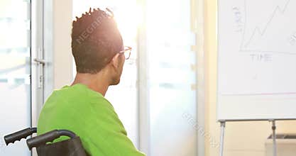 Casual businessman in wheelchair listening to presentation