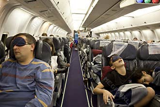 The passengers are sleeping in the cabin in flight