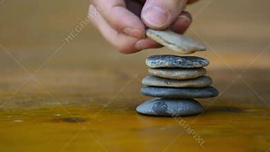 Person Stacking Rocks for Imagination and Mediation